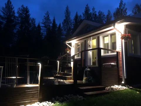 Punainen omakotitalo ja valaistu terassi syysiltana